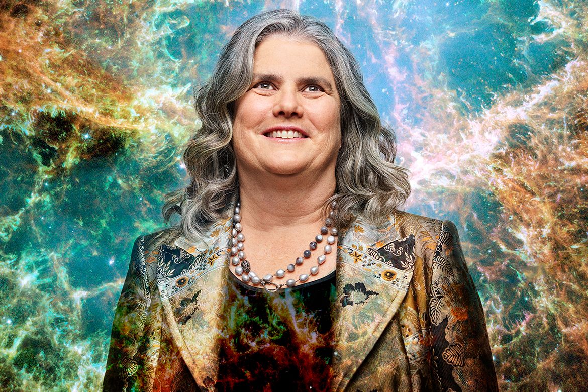 Andrea Ghez smiling in front of a colorful nebula